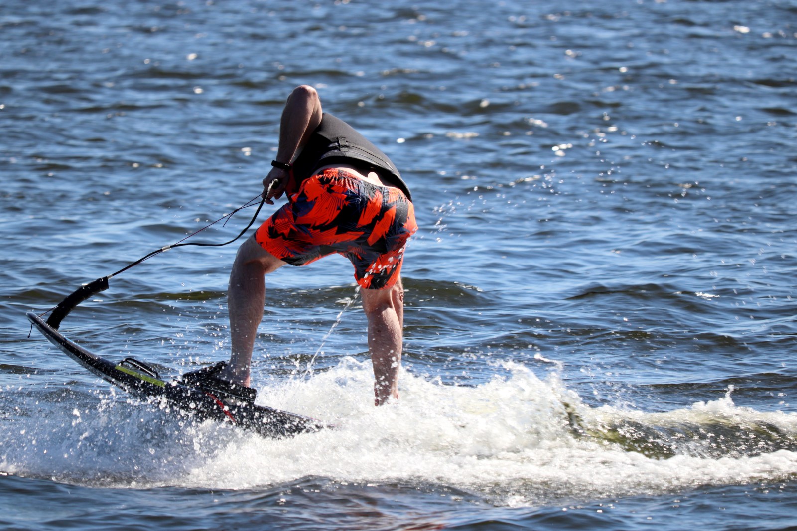 Jet surfing on a water, man riding on jet surfboard. Surfer on the sea, summer sport Jet surfing on a water, man riding on jet surfboard. Surfer on the sea, summer sport